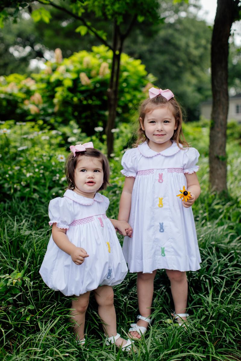Girls white smocked Easter dress with embroidered bunny accents down the front of the dress by Aspen Claire.